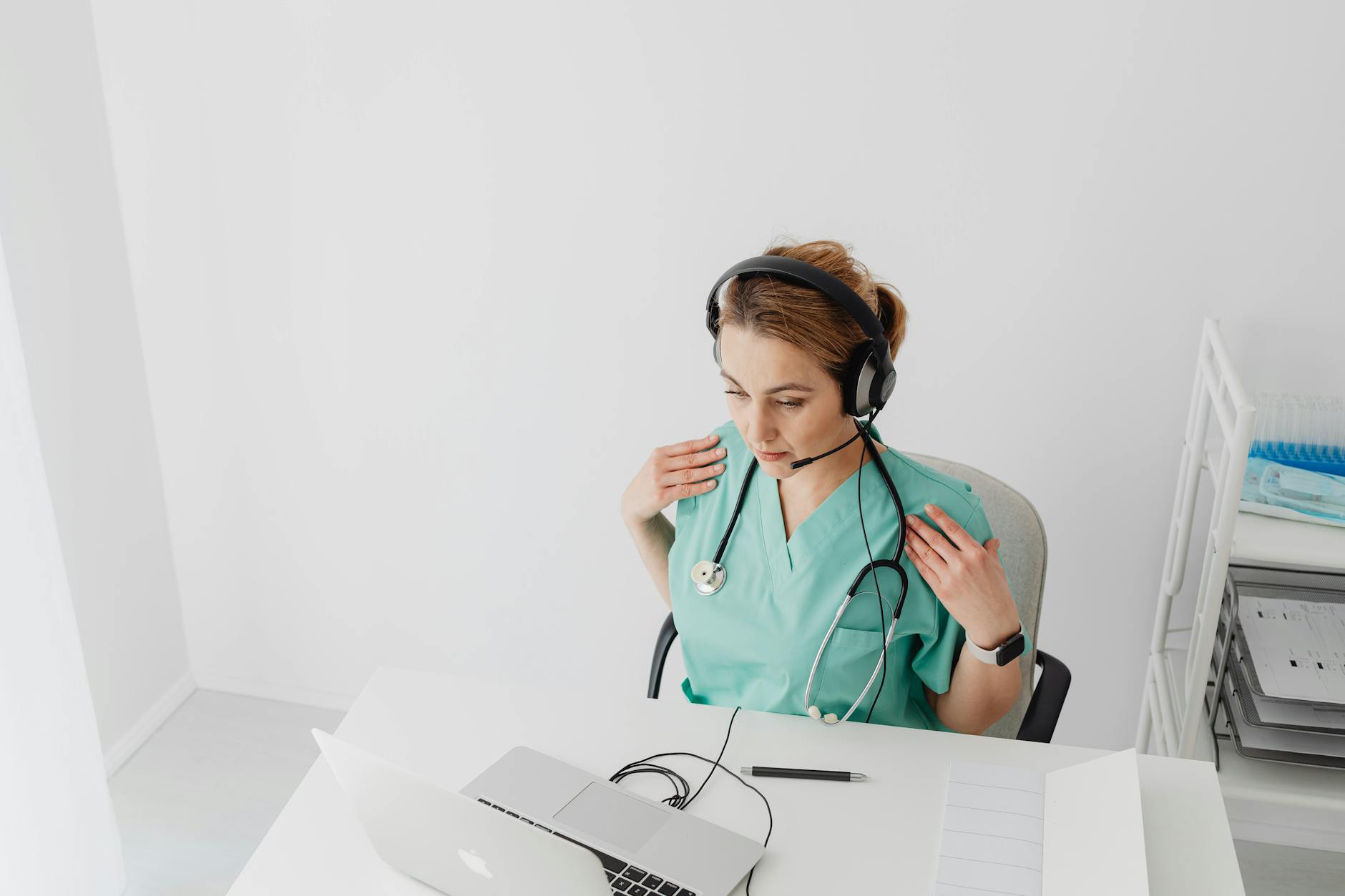 Female nurse practitioner with stethoscope conducting a telehealth video consultation with patients online, California